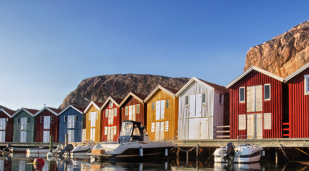 Kulisse der klassischen kleinen schwedischen Holzhäuser von einem Kanu aus fotografiert.