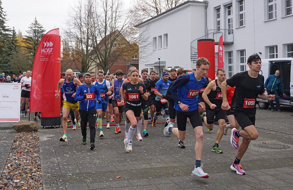 eine vielzahl von männlichen und weiblichen Joggern, unterschiedlichen Alters, an der Startlinie zum 29. Hochschullauf, auf dem Mensavorplatz