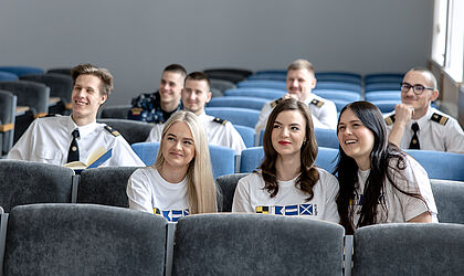 eine Gruppe junger lächelnder Menschen in einem Vorlesungssaal