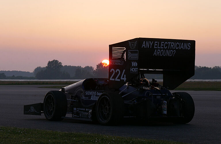 Der 1. voll-elektrische Formel-Student-Rennwagen des Baltiv Racing Teams auf einer Rennstrecke bei Sonnenuntergang.