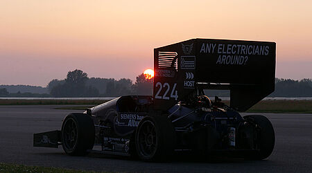 Der 1. voll-elektrische Formel-Student-Rennwagen des Baltiv Racing Teams auf einer Rennstrecke bei Sonnenuntergang.