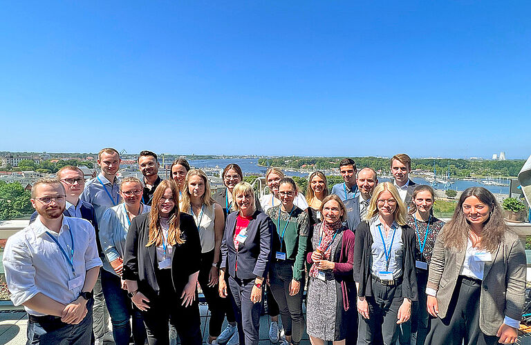 Gruppenfoto bei der Branchenkonferenz Gesundheitswirtschaft auf einer Dachterrasse bei strahlendem Sonnenschein