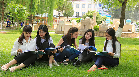 Studentinnen sitzen vor der Tashkent State University of Economics