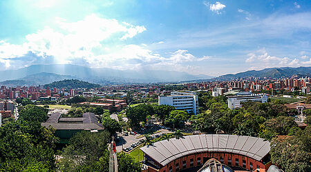 Luftaufnahme des Campus Universidad Pontificia Bolivariana bei Sonnenschein und mit Bergkulisse im Hintergrund