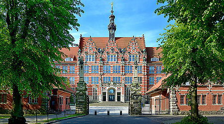 Historisches Gebäude der Gdańsk University of Technology in Danzig mit Bäumen im Vordergrund