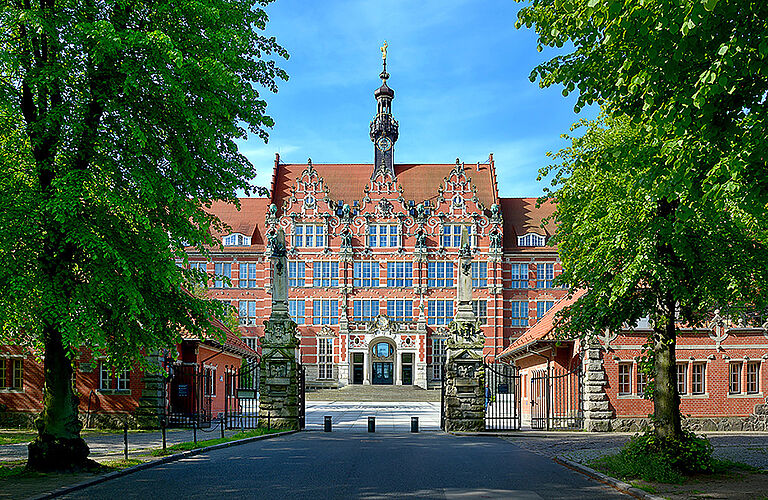 Historisches Gebäude der Gdańsk University of Technology in Danzig mit Bäumen im Vordergrund