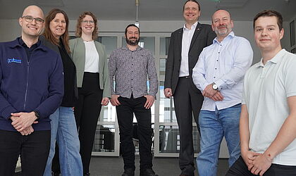 Christian Eschenburg, Liane Kantz, Marie Schlosser, Sven Klimaschewski, Prof. Dr.-Ing. Mark Vehse, Dr. Kai Masur und Torben Haupt posieren für ein Gruppenfoto auf einer Treppe