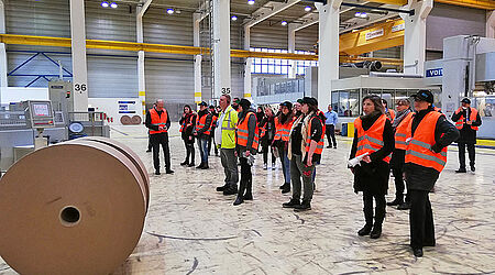 Gruppenfoto von Studierenden in Maschienenhalle in Warnwesten