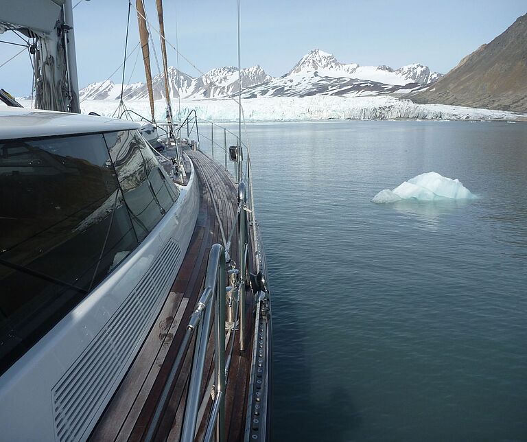 Blick von einem Boot, vermutlich einer Yacht, auf Berge mit Eis bedeckt.