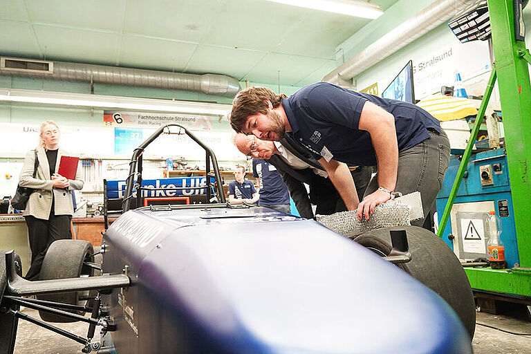 Ole Panzer und Staatssekretär Jochen Schulte am 2023-Formel-Student-Rennwagen des Baltic Racing Teams