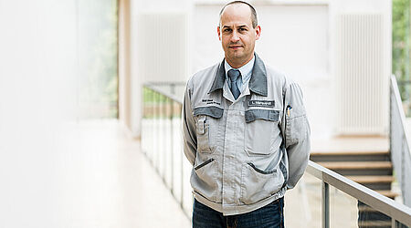 Prof. Leander Marquardt mit Werkstattjacke auf einem Flur