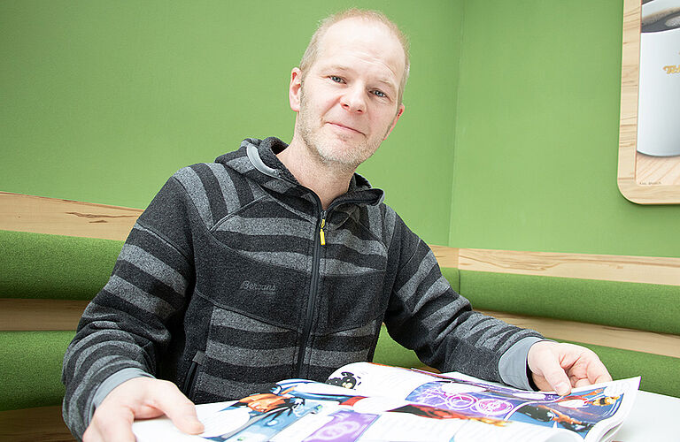 Prof. Gero Szepannek mit dem KI-Comic in der Cafeteria der HOST