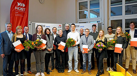 Ein Gruppenfoto mit gut 20 Personen, die teilweise Blumen und Urkunden halten.