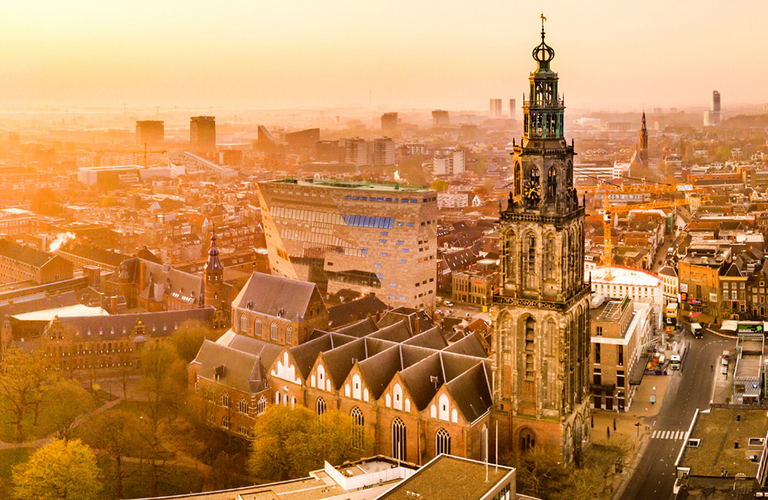 Luftaufnahme vom Campus der Hanzehogeschool und Kirchengebäude bei Sonnenuntergang