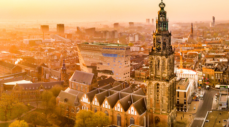 Luftaufnahme vom Campus der Hanzehogeschool und Kirchengebäude bei Sonnenuntergang