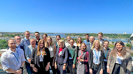 Gruppenfoto bei der Branchenkonferenz Gesundheitswirtschaft auf einer Dachterrasse bei strahlendem Sonnenschein